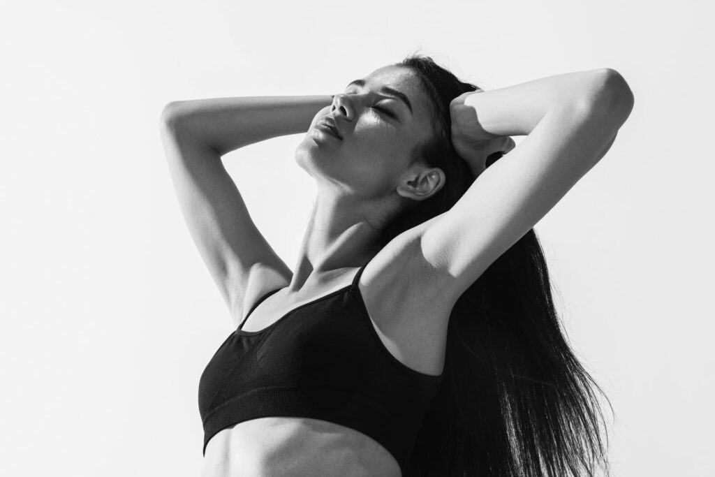 Une femme les bras levés sans défaut esthétique apparent illustrant le lifting des bras proposé par le Dr Ruiz à Nantes